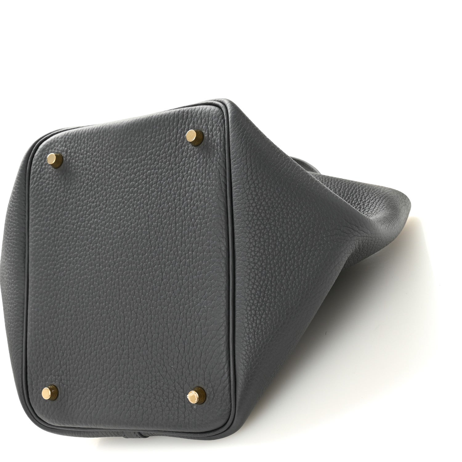 Dark gray leather handbag with corner studs and textured grain on angled side
