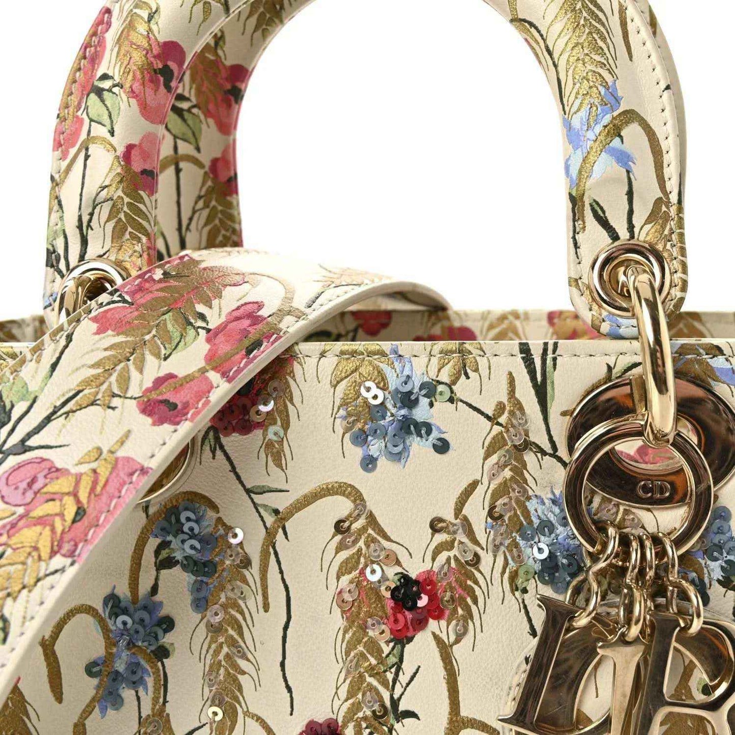 Floral embroidered top handles with gold-tone ring hardware on a cream tote