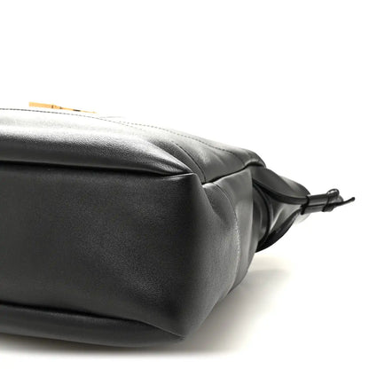 Black lambskin tote corner with drawstring bow ties and smooth rounded edge.