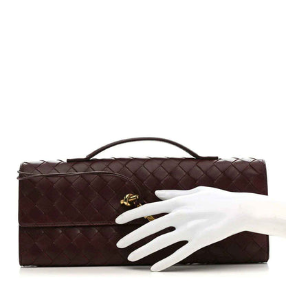 Bottega Veneta dark burgundy intrecciato clutch with top handle and gold hardware