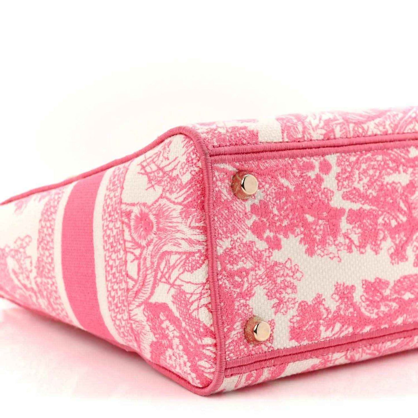 Pink tote bag corner with top handle, patterned fabric, and gold grommets