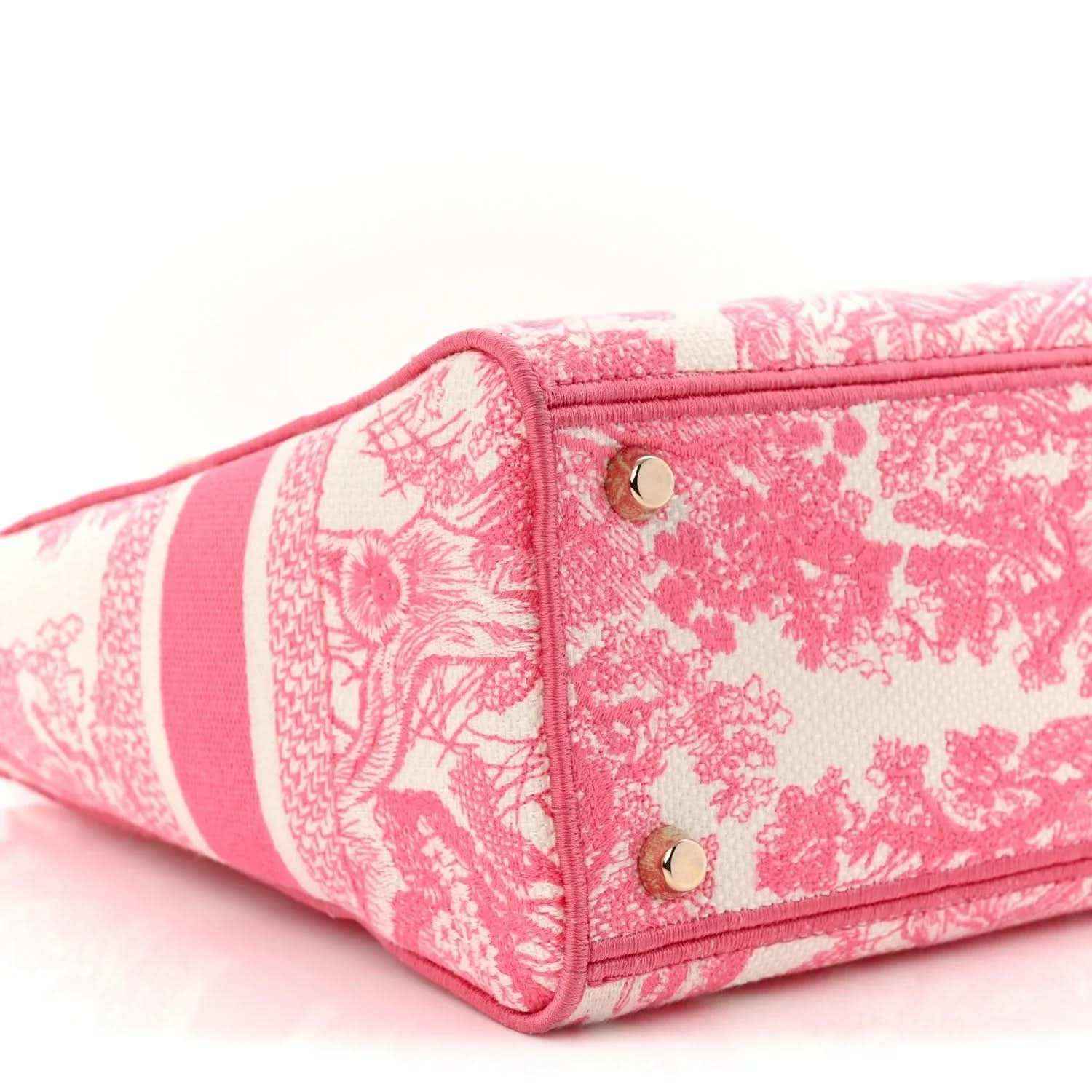 Pink tote bag corner with top handle, patterned fabric, and gold grommets