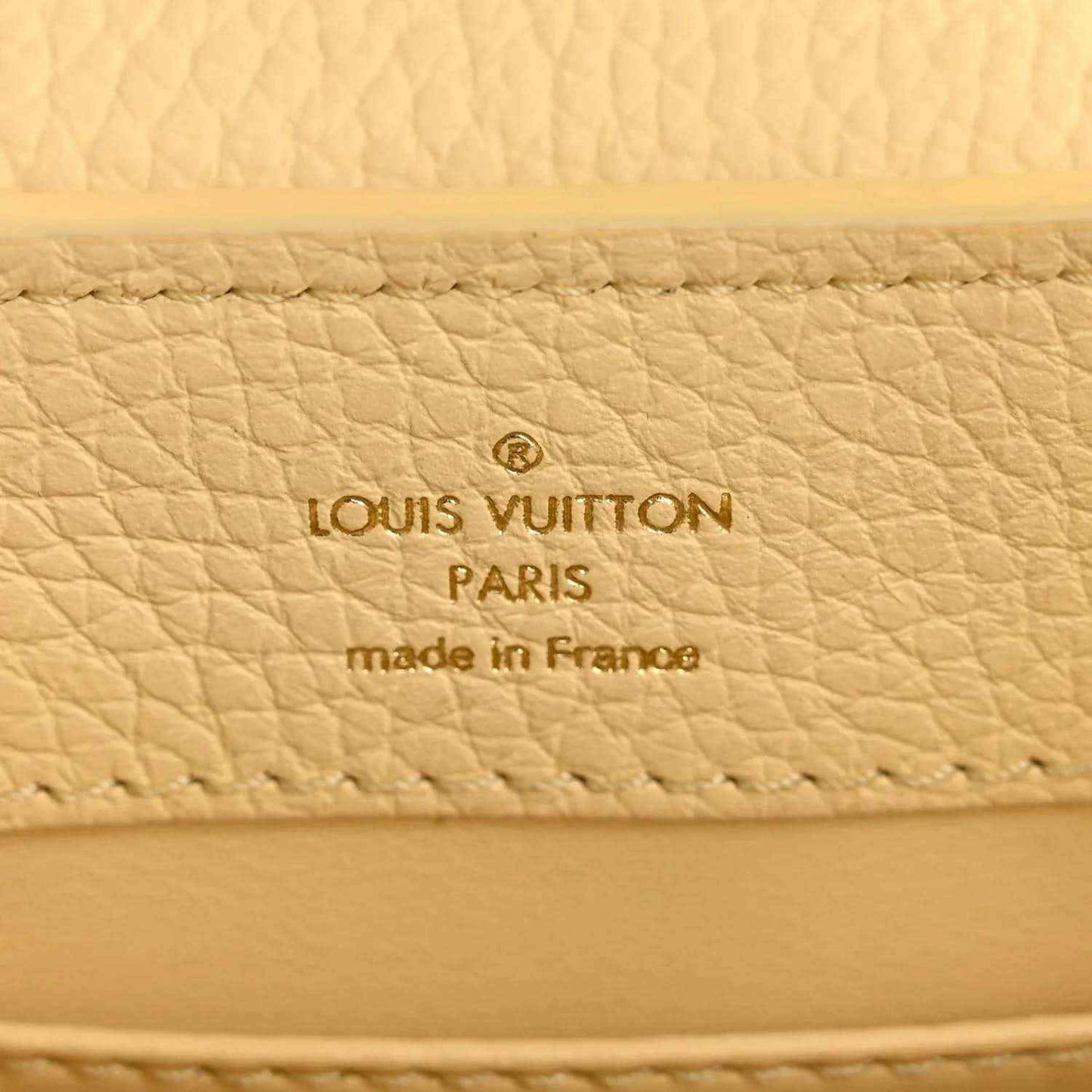 Cream leather interior panel with Louis Vuitton Paris and made in France text.