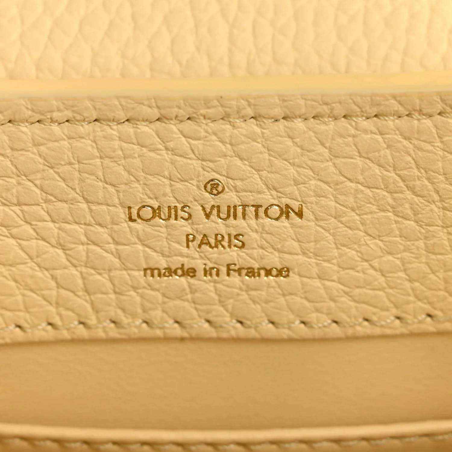 Cream leather interior panel with Louis Vuitton Paris and made in France text.