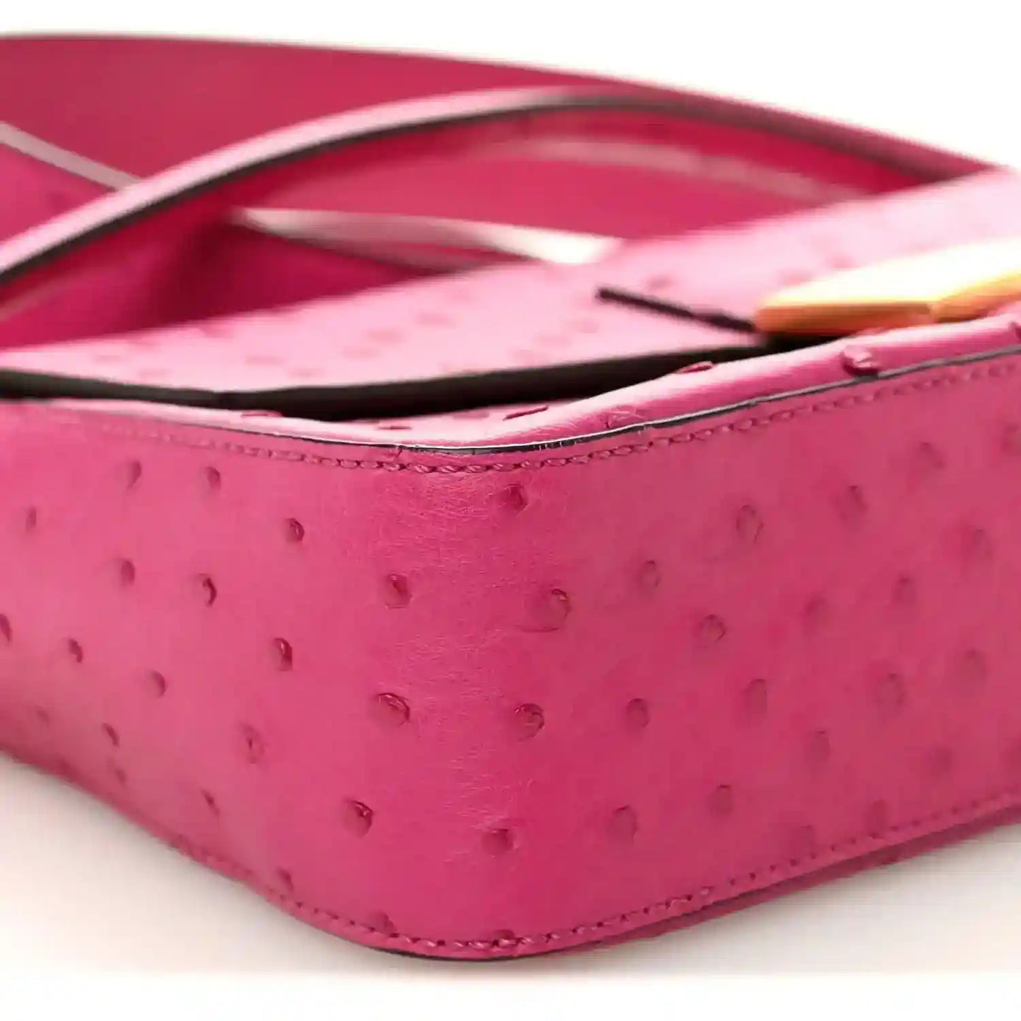 Pink ostrich leather baguette with black strap and gold-tone edge detail