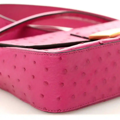 Pink ostrich leather baguette with black strap and gold-tone edge detail