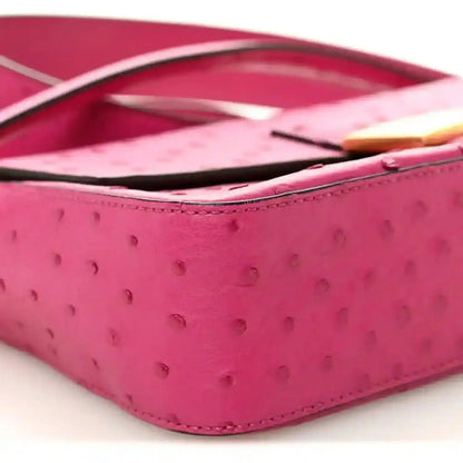 Pink ostrich leather baguette with black strap and gold-tone edge detail