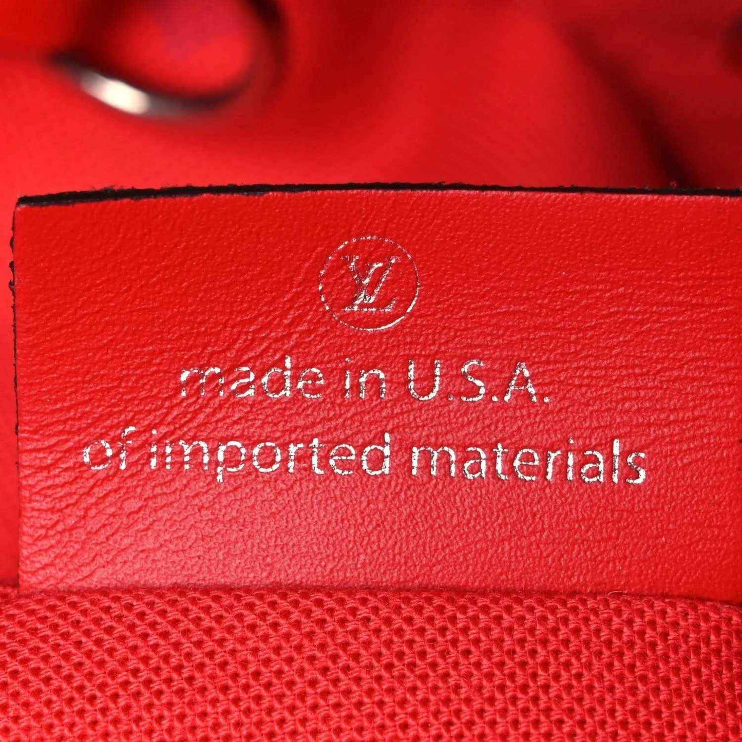 Red leather tag reading "made in U.S.A." on Louis Vuitton tote