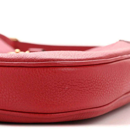 Red leather hobo bag close-up of curved base and pebbled texture