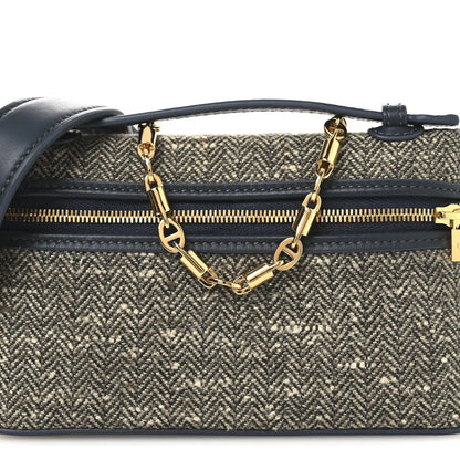 Mini pouch front view with herringbone fabric, navy strap, and gold chain centerpiece