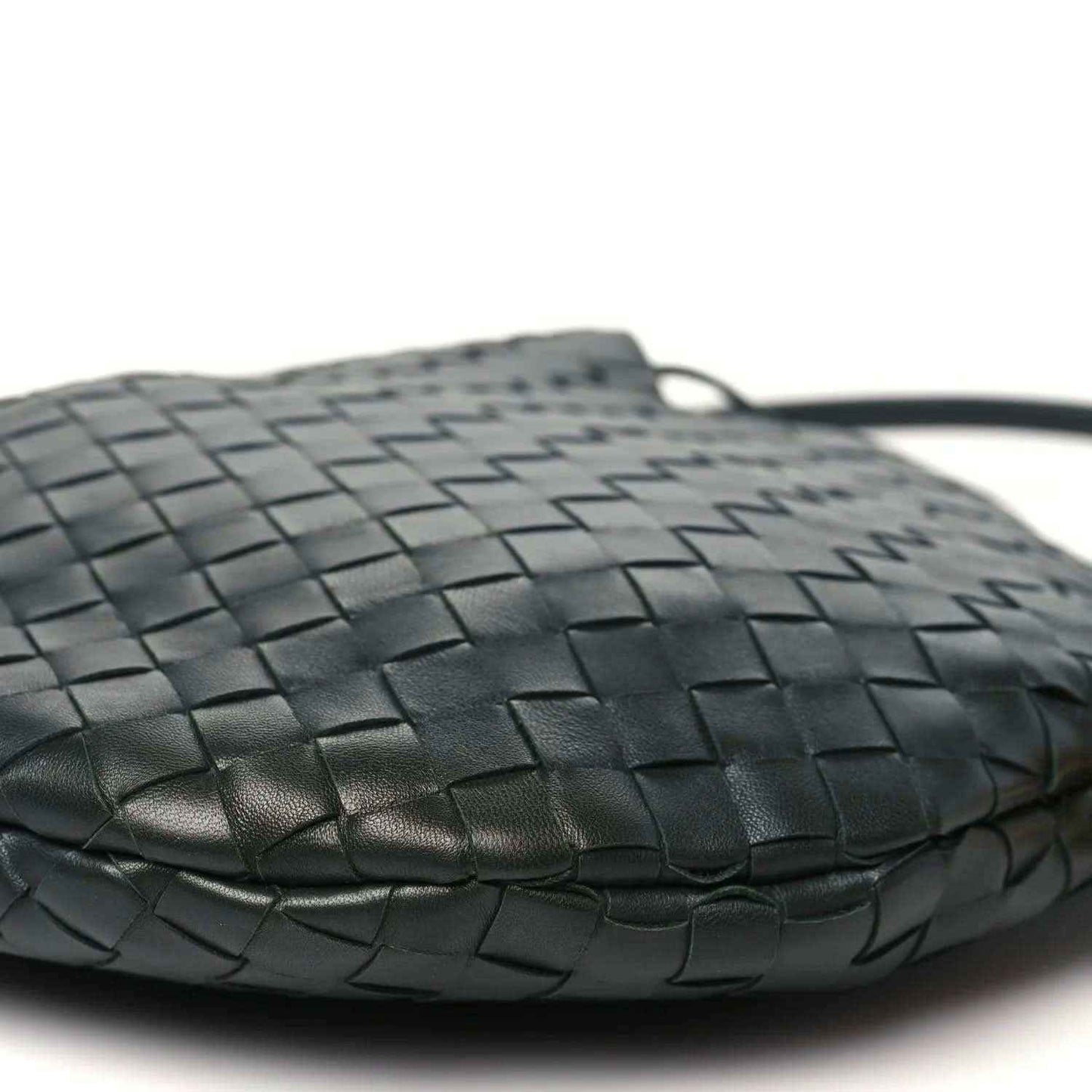 Close-up of dark green woven leather hobo top edge and handle loop
