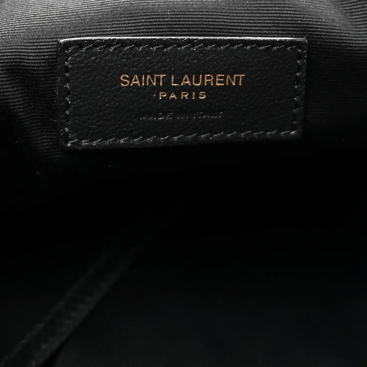 Black leather brand patch reading SAINT LAURENT PARIS on tote lining.