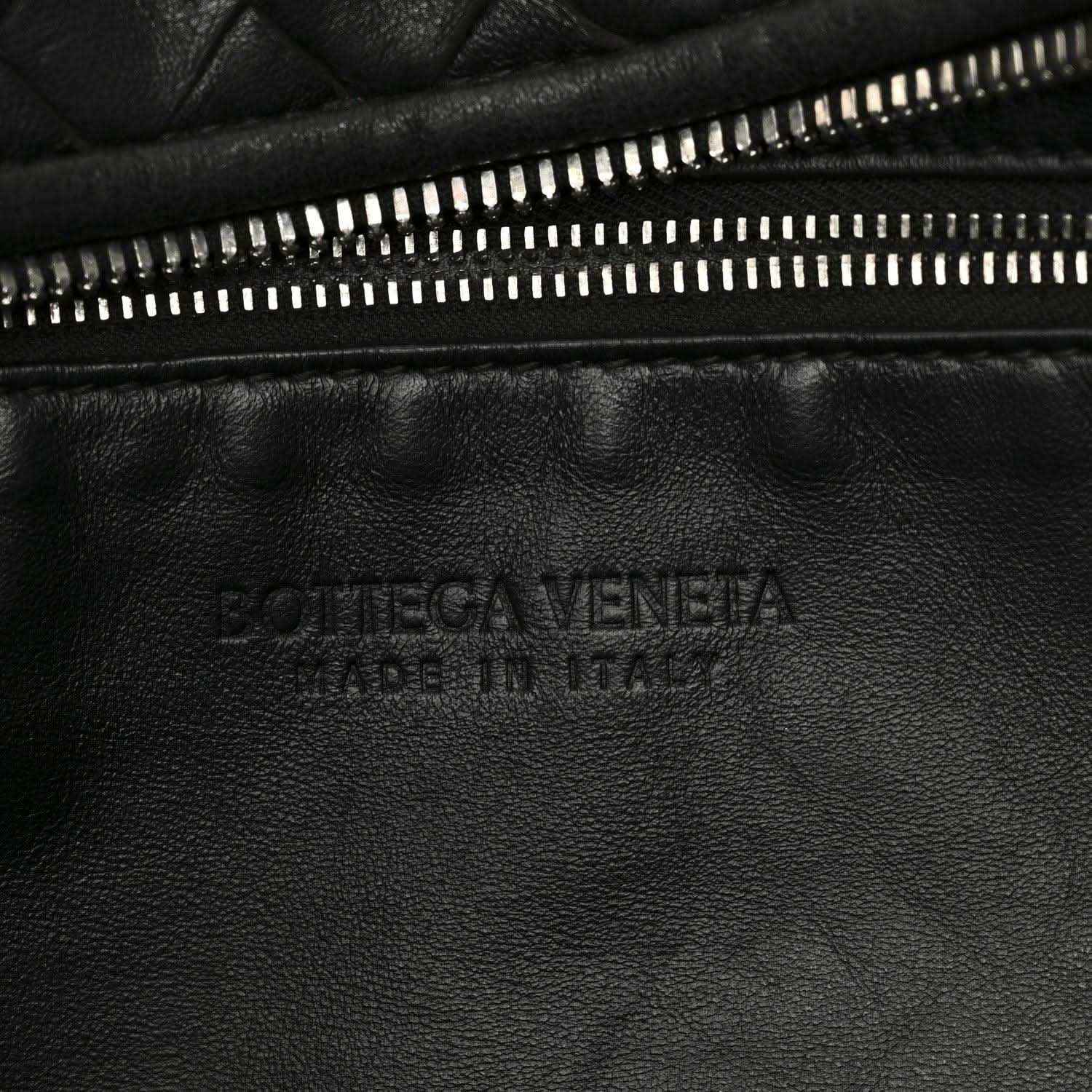 Black leather shoulder bag with gold-tone zipper and debossed logo panel