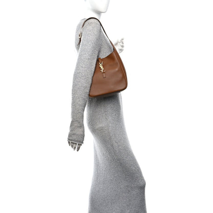 Saint Laurent hobo bag, brown leather front with logo, shown from side on model