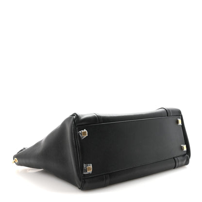 Black leather luggage bag with structured sides and gold-tone hardware.