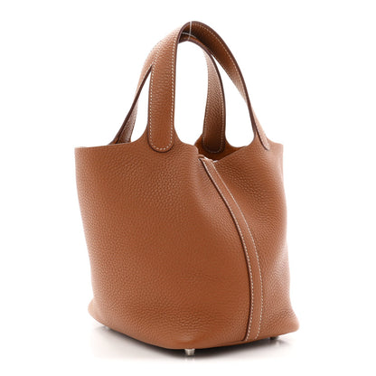 Brown leather bucket tote bag with side zipper detail and curved handles