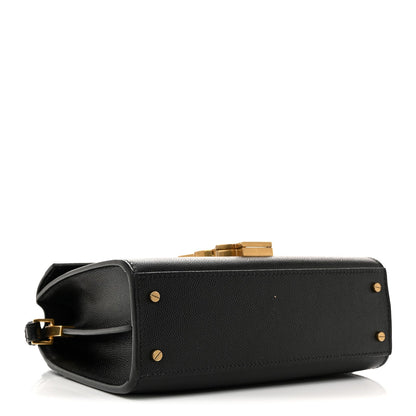 Black leather mini top-handle bag with gold studs and flap opening.