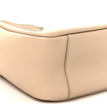 Light beige leather hobo bag corner with smooth texture and stitched panel