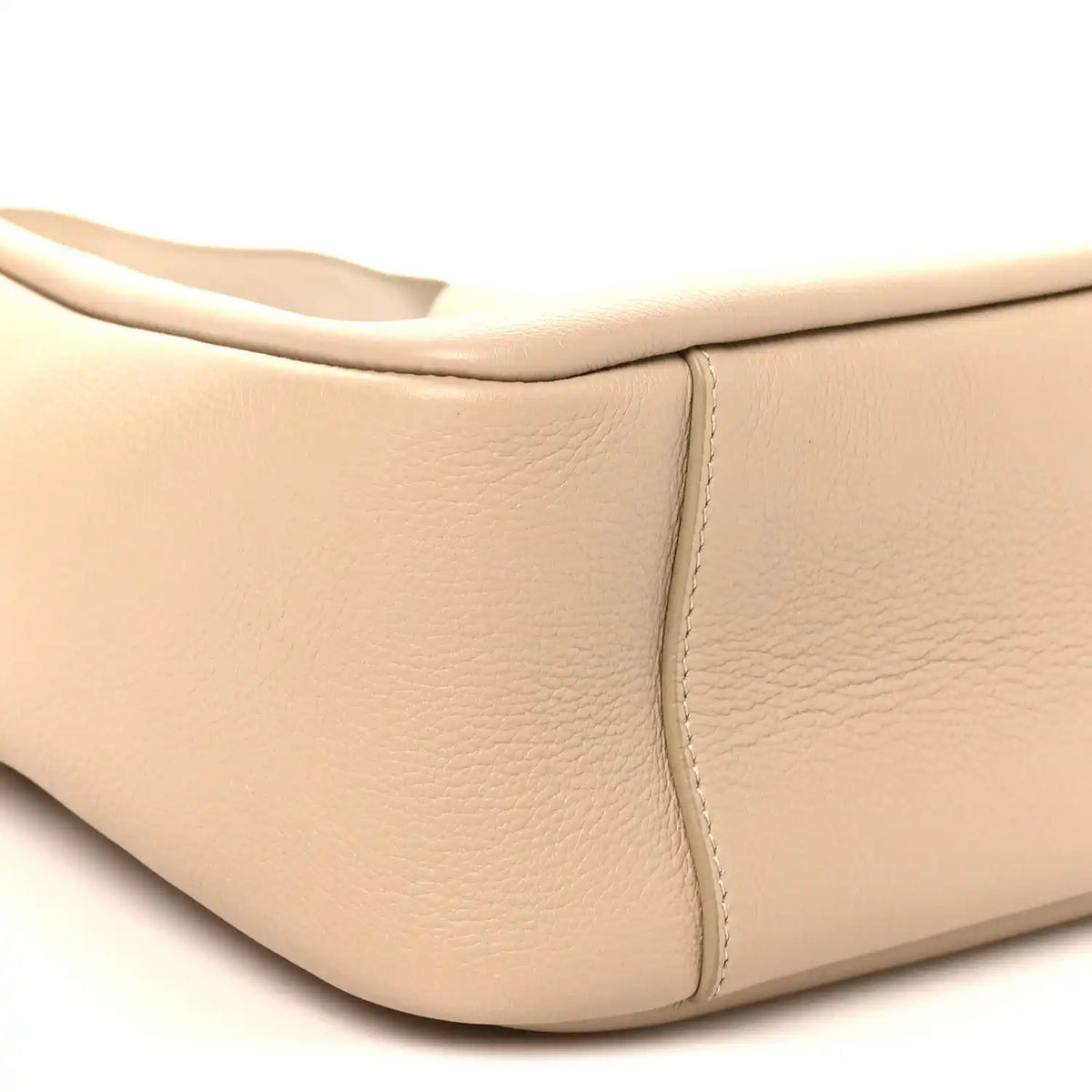Light beige leather hobo bag corner with smooth texture and stitched panel