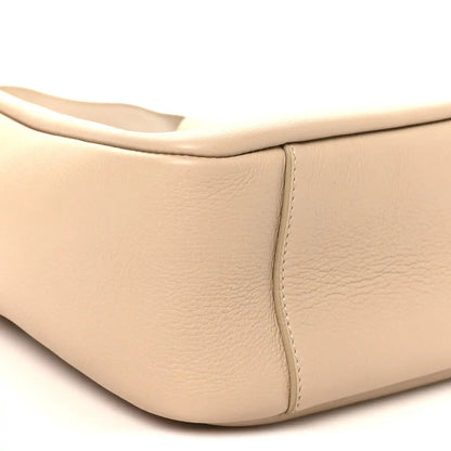 Light beige leather hobo bag corner with smooth texture and stitched panel