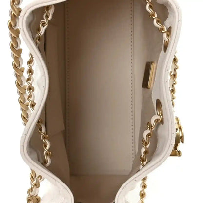 White mini handbag interior with brown lining and gold trim near the side wall