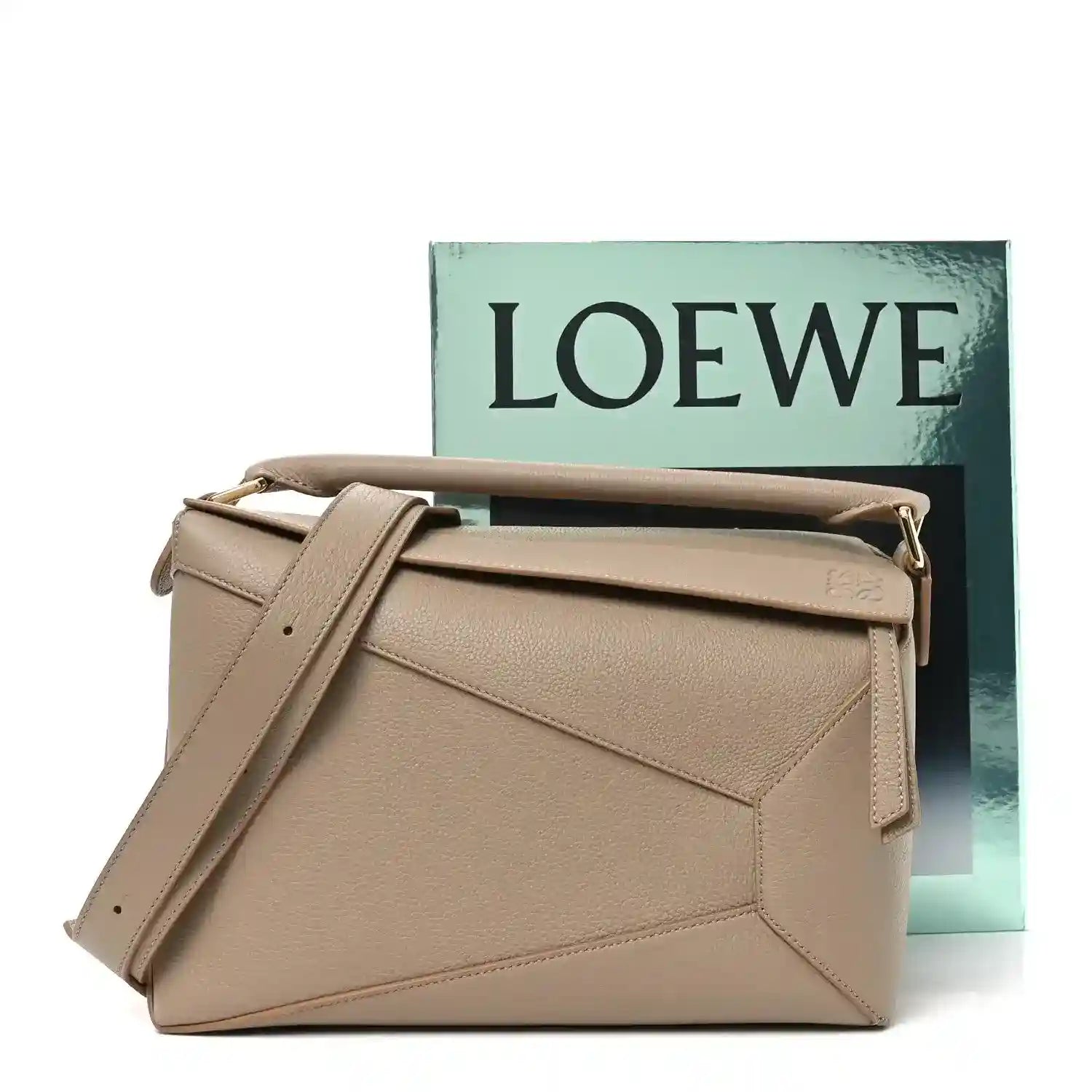 Sand leather crossbody bag with top handle, shoulder strap, and gold-tone side hardware.