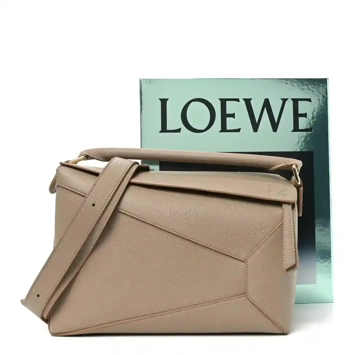 Sand leather crossbody bag with top handle, shoulder strap, and gold-tone side hardware.