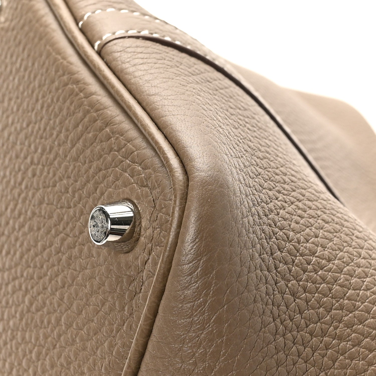 Taupe pebbled leather tote bag corner with polished turn-lock and stitched strap