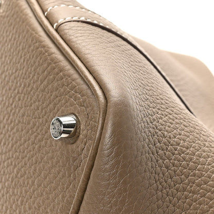 Taupe pebbled leather tote bag corner with polished turn-lock and stitched strap