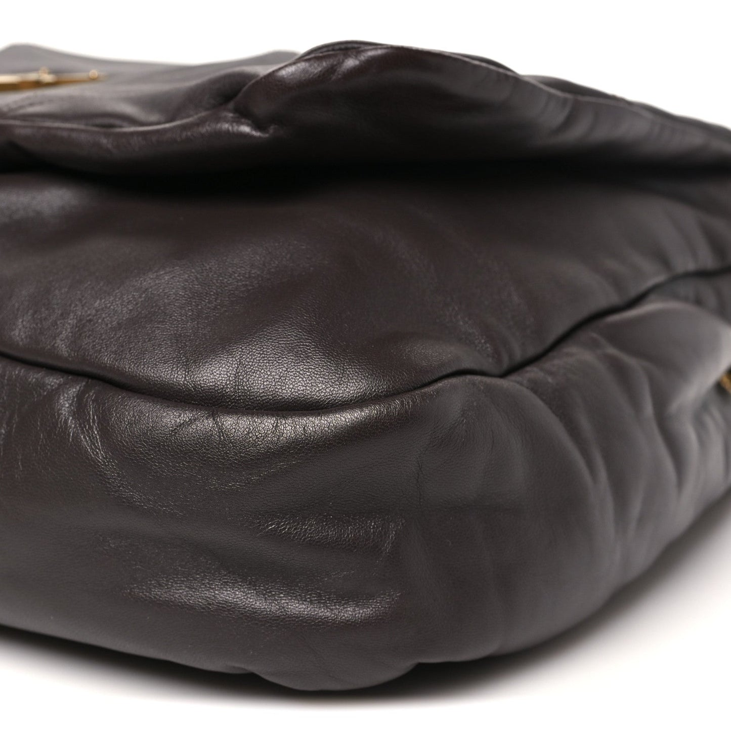 Quilted dark-brown leather shoulder bag exterior detail with soft horizontal seam