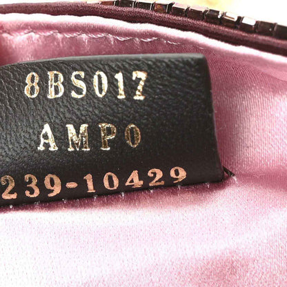 Mini baguette handbag care label with code text on black leather patch