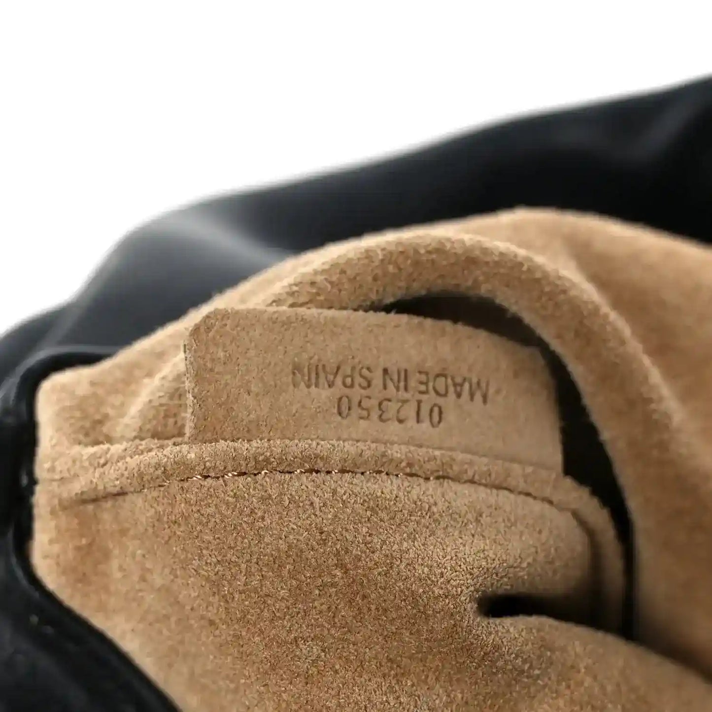 Black clutch lining with embossed “MADE IN SPAIN” marking near opening.