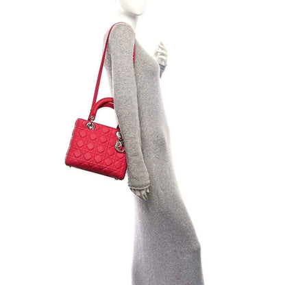 Pink quilted handbag with crossbody strap and silver rings, side view