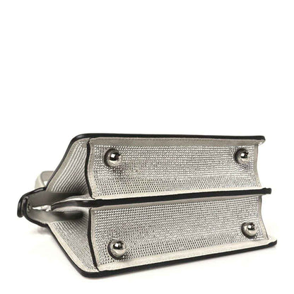 Small satchel bottom view with two rows of studs, snap closure, and contrast trim