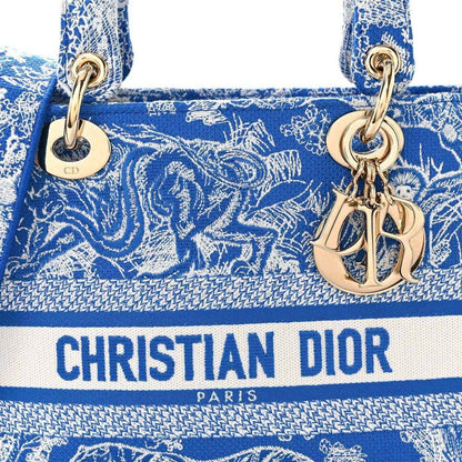 Christian Dior blue toile handbag front with gold-tone rings and Dior logo stripe