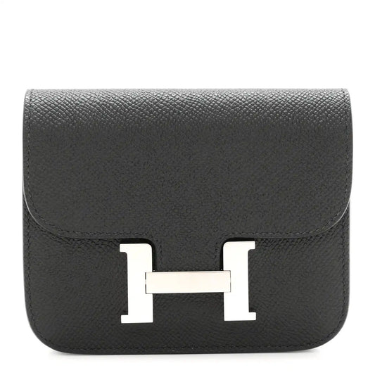 Black slim wallet with front H clasp in palladium-tone metal.