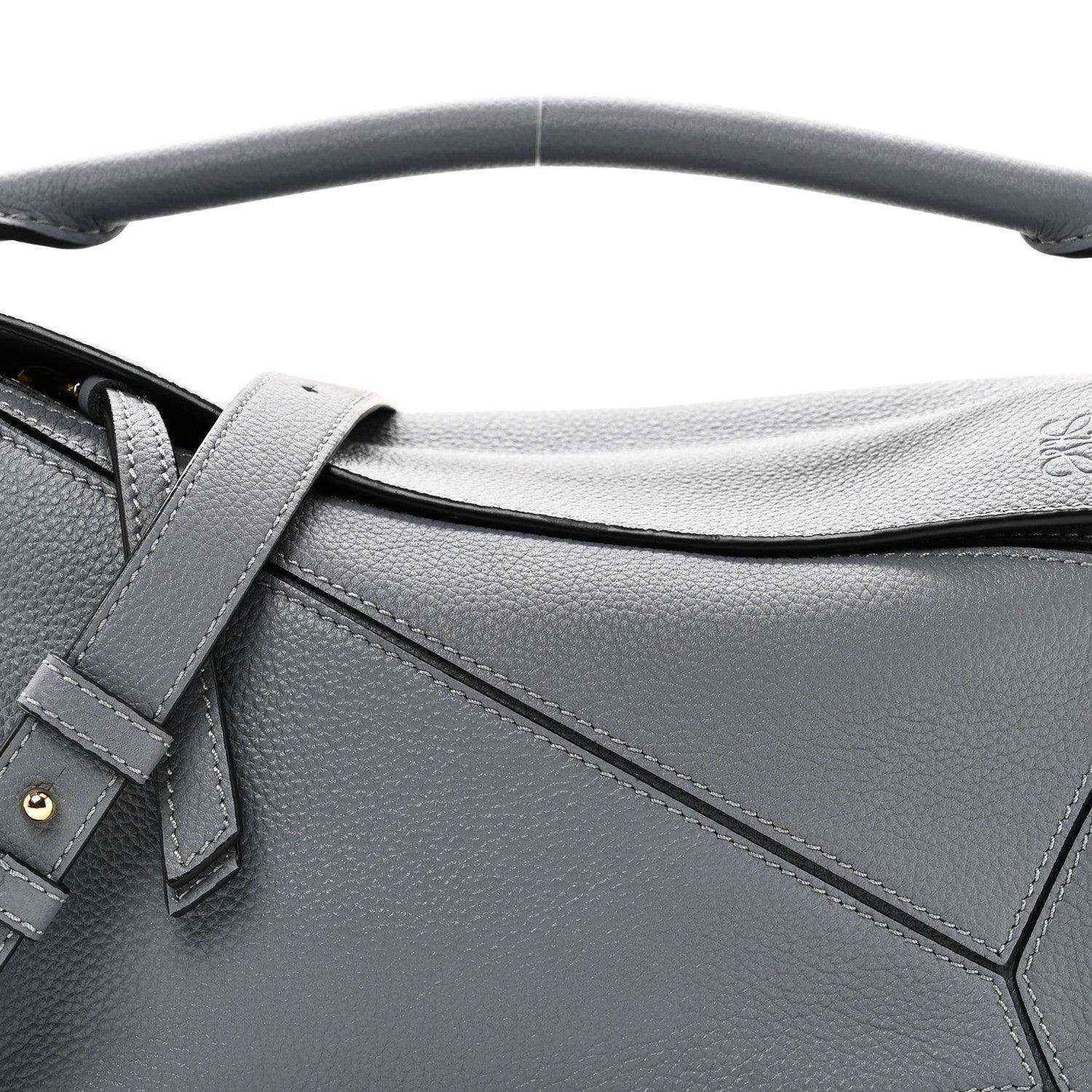 Small puzzle bag front detail in dark gray leather with stitched panel seams