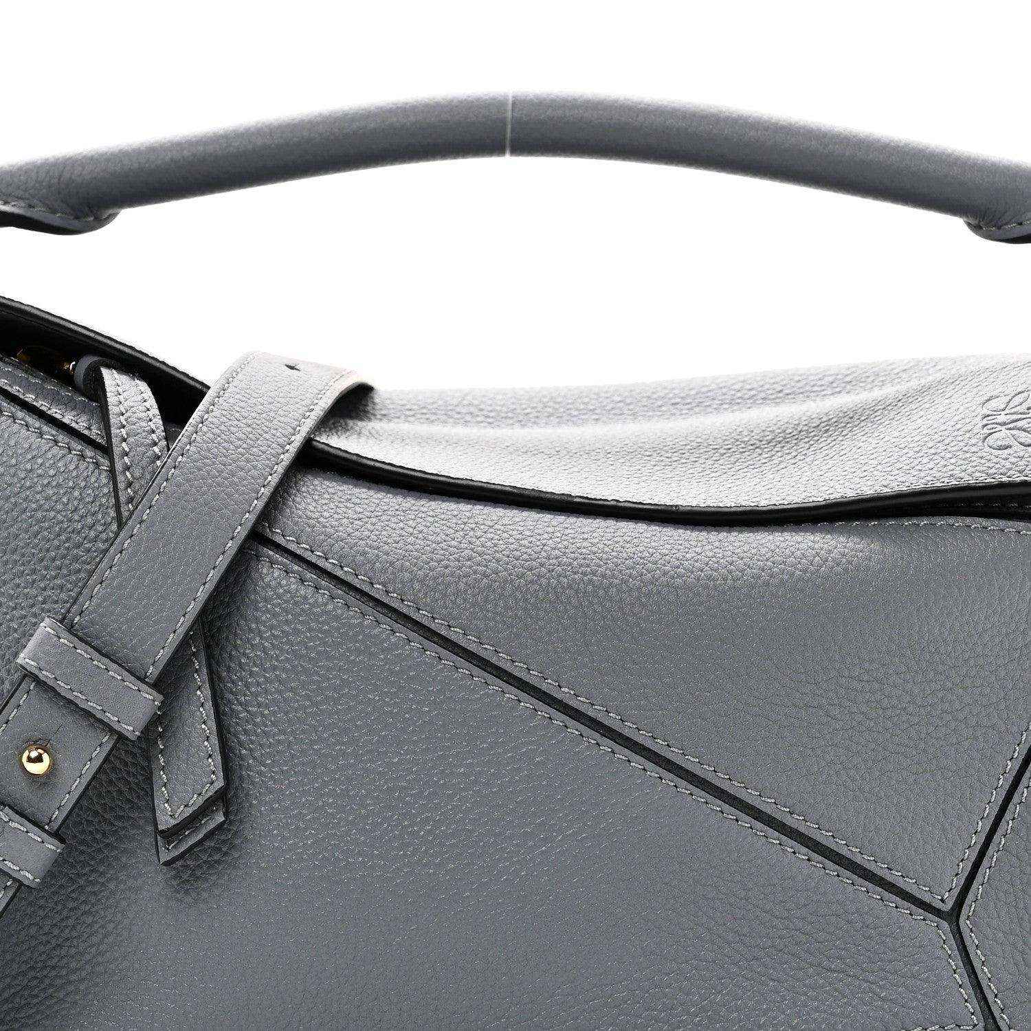 Small puzzle bag front detail in dark gray leather with stitched panel seams