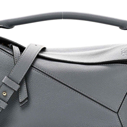 Small puzzle bag front detail in dark gray leather with stitched panel seams