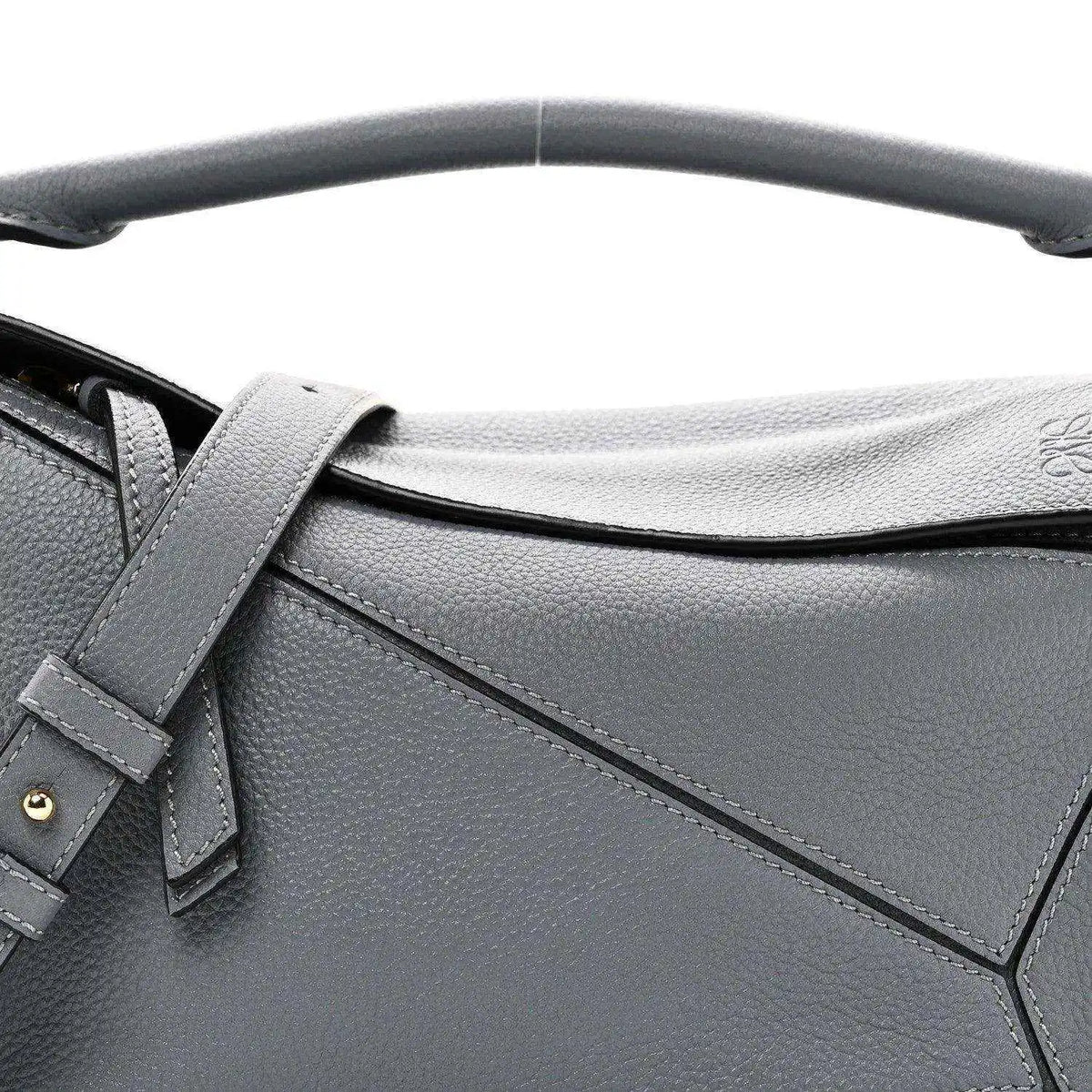 Small puzzle bag front detail in dark gray leather with stitched panel seams