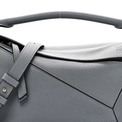 Small puzzle bag front detail in dark gray leather with stitched panel seams