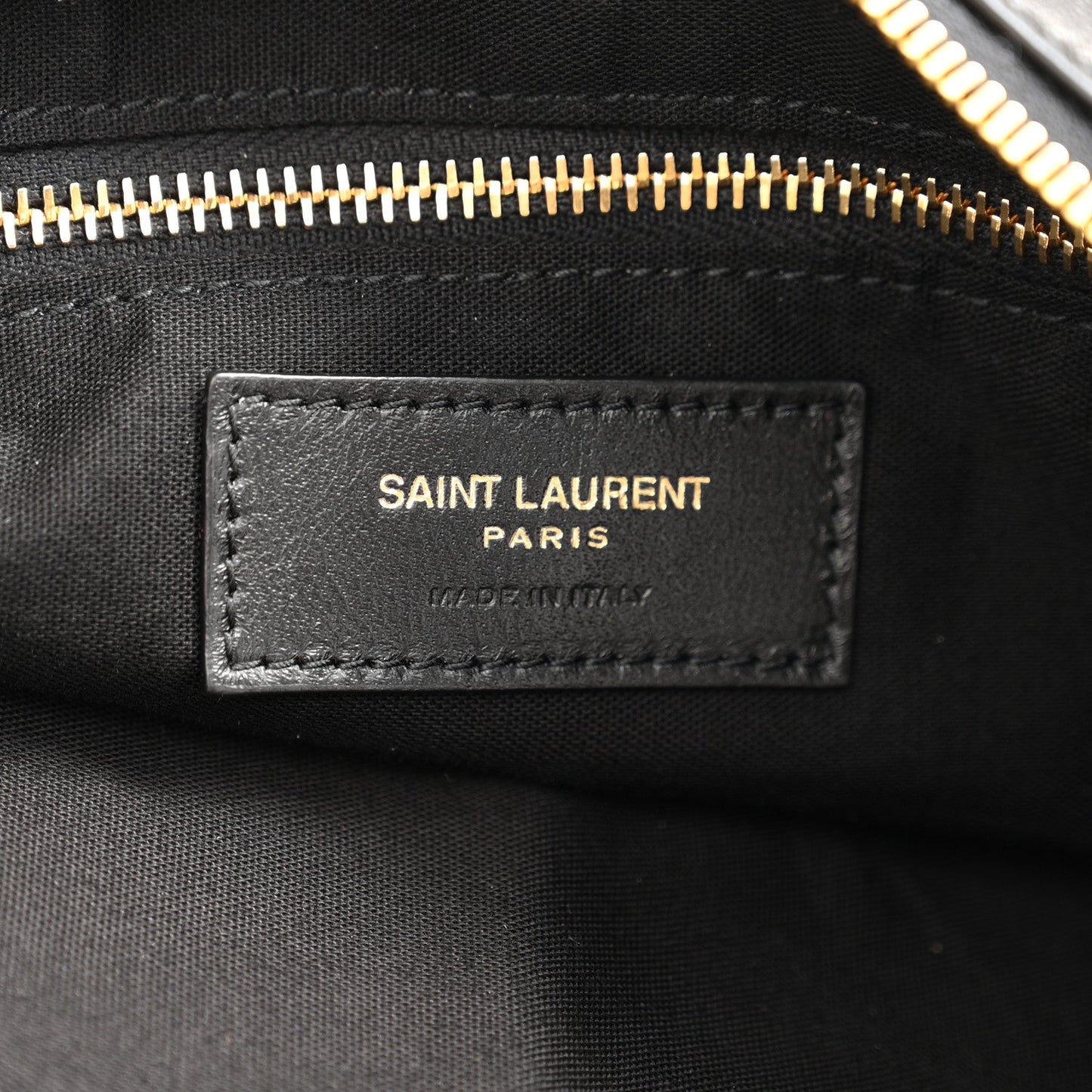 Saint Laurent Paris leather label on black hobo bag with gold zipper trim