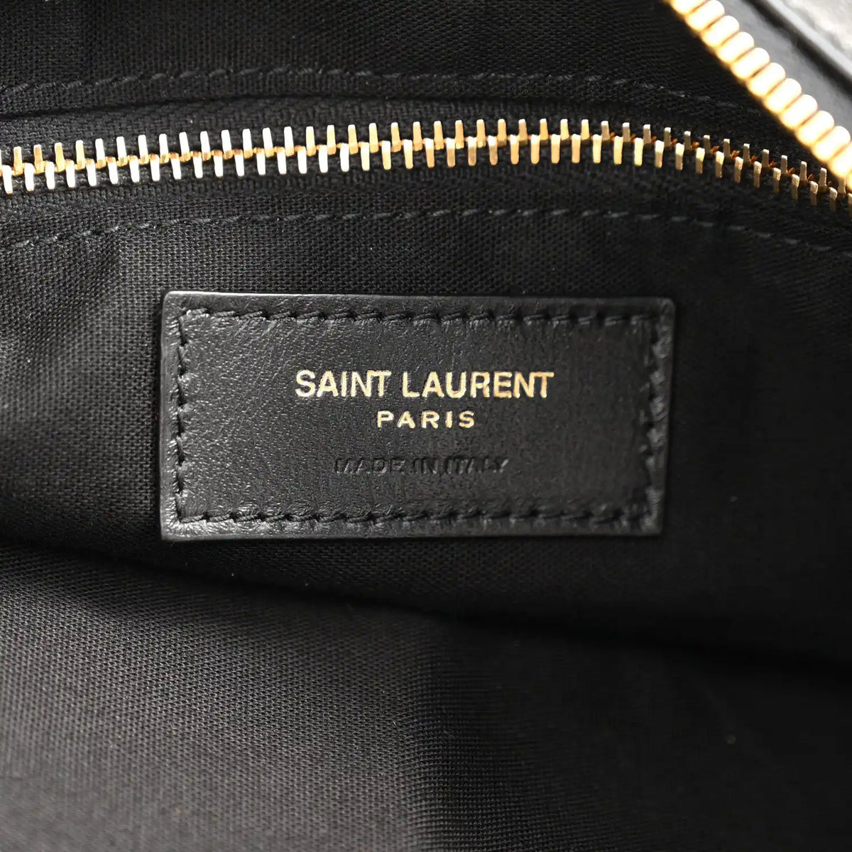 Saint Laurent Paris leather label on black hobo bag with gold zipper trim