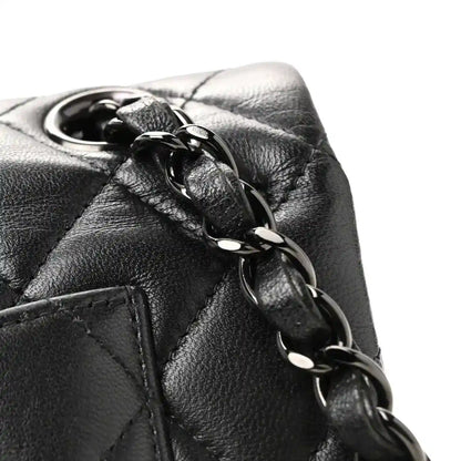 Chanel quilted lambskin bag hardware close-up with dark black leather loop and chain