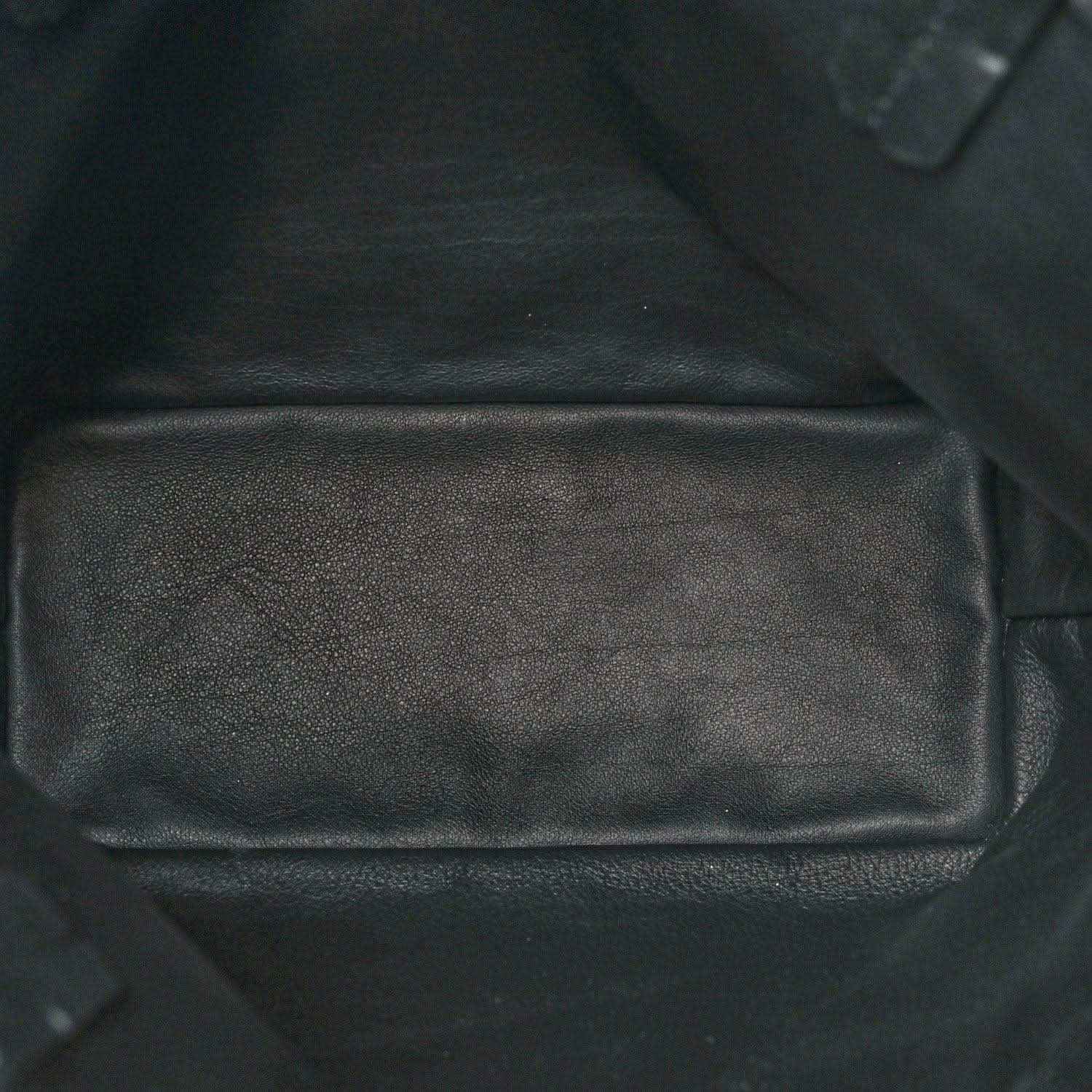 Black leather-like interior pocket panel of a reversible mini tote bag with seams.