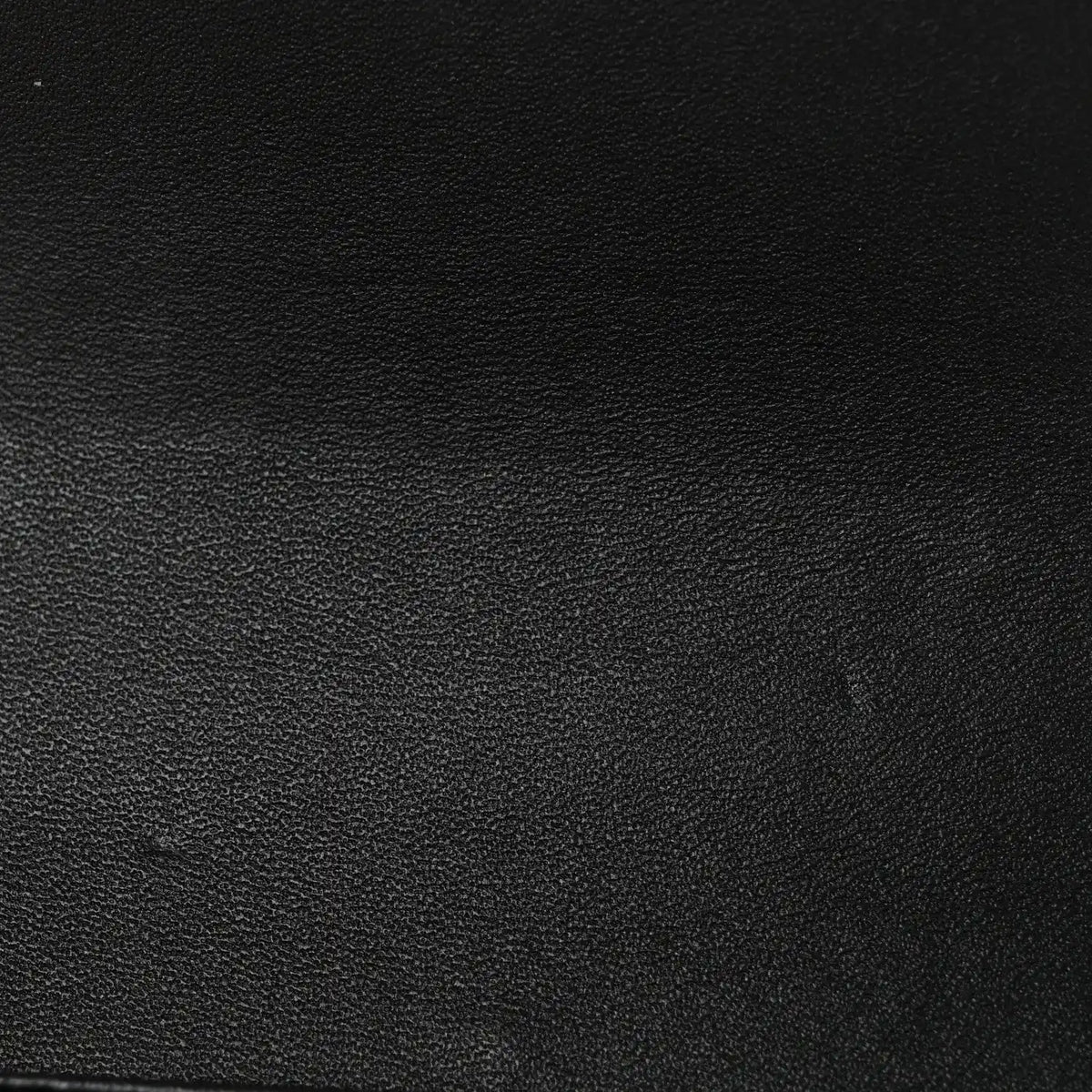 Black shiny calfskin leather texture close-up