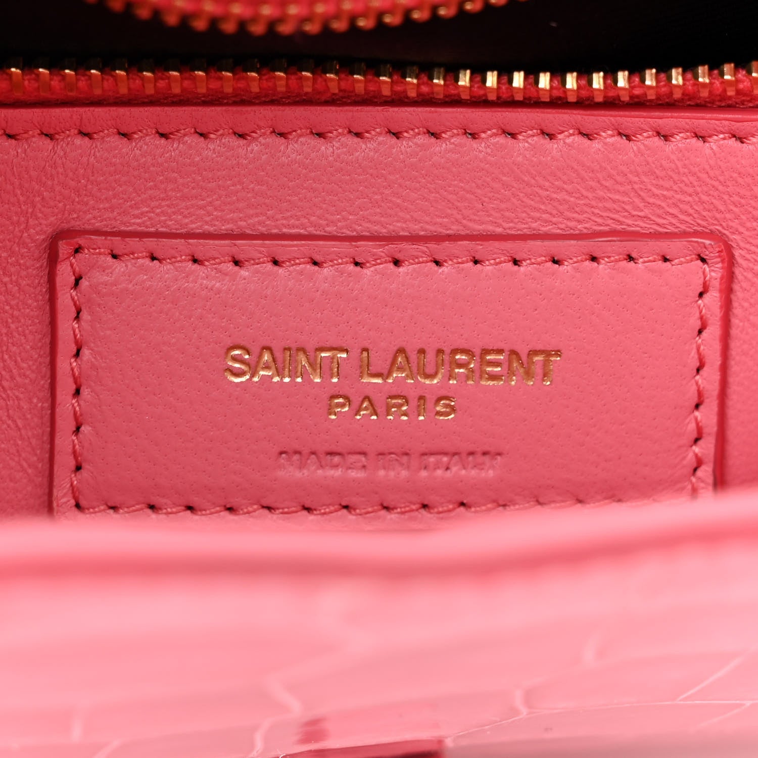 Pink leather bag label inside lining with “SAINT LAURENT PARIS” stitching