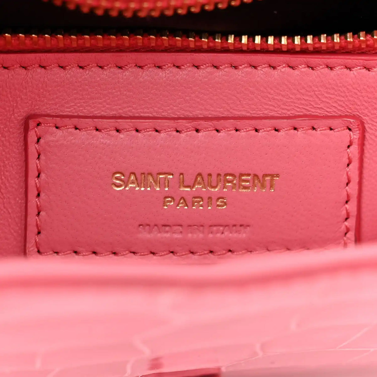 Pink leather bag label inside lining with “SAINT LAURENT PARIS” stitching