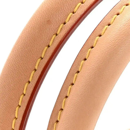 Tan leather strap seam detail with yellow stitching on monogram tote bag
