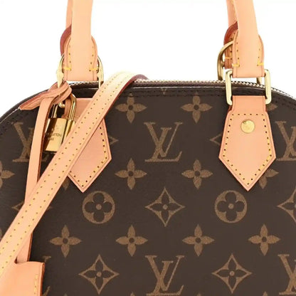 Monogram tote bag front view with tan leather strap ties, handles, and gold clasp